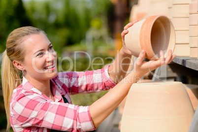 garden center woman putting clay pots shelf
