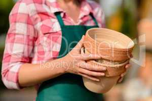 two clay pots held by gardener close-up