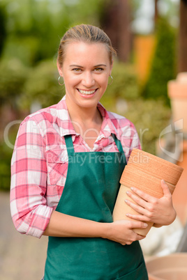 smiling garden center woman holding clay pots