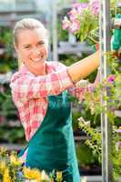 smiling garden center woman working potted flowers