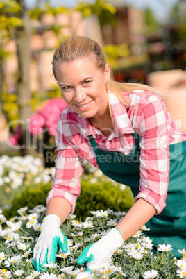 happy female worker at garden center flowers