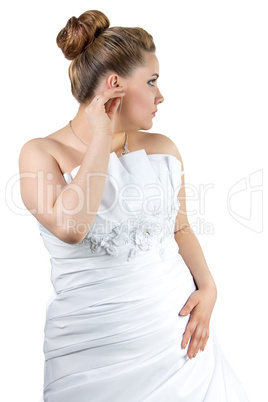 Woman in white wedding dress touching ear