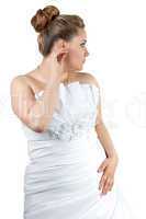Woman in white wedding dress touching ear