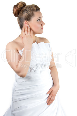 Woman in white wedding dress touching her ear