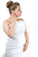 Woman in white wedding dress touching her ear