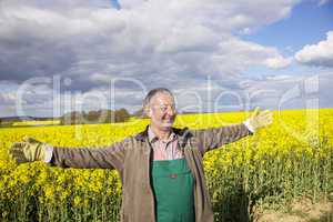 Farmer with outstretched arm at the rape field