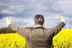 Farmer with outstretched arm at the rape field