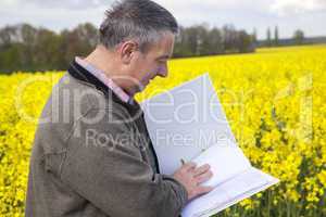 Farmer with file folders in rape field