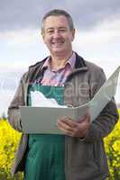 Farmer with file folders in rape field