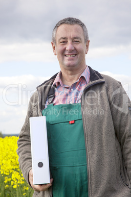 Farmer with file folders in rape field