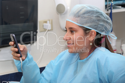 happy female surgeon reading message at mobile phone