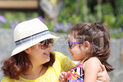 Portrait of mother and daughter outdoors looking each other in s