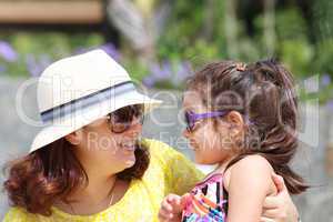 Portrait of mother and daughter outdoors looking each other in s