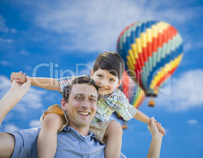Father and Son Playing Piggyback with Hot Air Balloons Behind