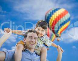 Father and Son Playing Piggyback with Hot Air Balloons Behind