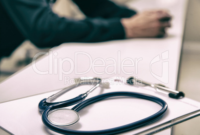 Stethoscope on the desk with doctor in background