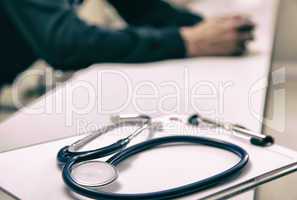 Stethoscope on the desk with doctor in background