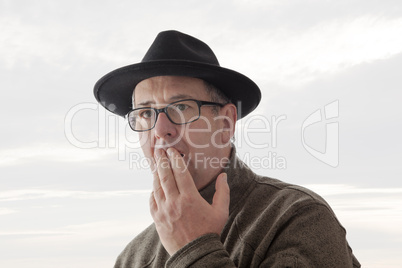 Serious man with hat and anxious glance