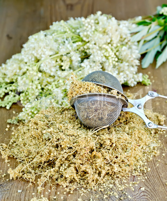 Herbal tea of meadowsweet in strainer on board