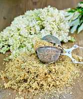 Herbal tea of meadowsweet in strainer on board