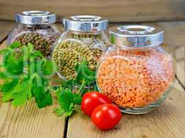 Lentils different in jars with parsley on board