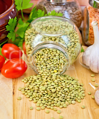 Lentils green in jar with tomato on board