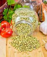 Lentils green in jar with tomato on board