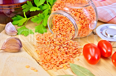 Lentils red in jar with tomato on board