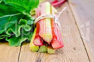 Rhubarb tied with twine with leaf on board