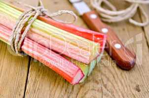 Rhubarb with twine and knife on board