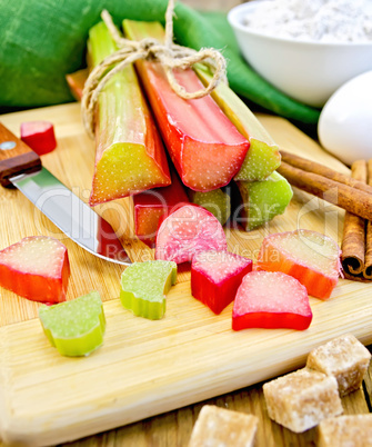 Rhubarb with sugar and knife on board