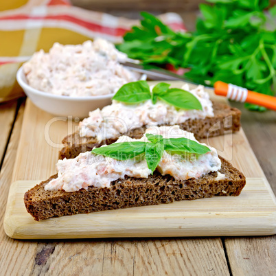 Sandwich with cream of salmon and knife on board