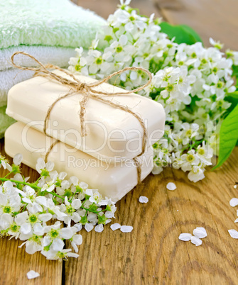 Soap with towel and bird cherry on board