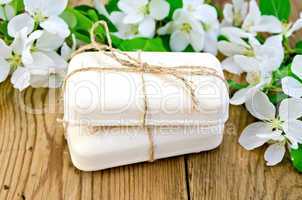 Soap with white flowers of apple on board