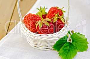 Strawberries in basket on napkin and board