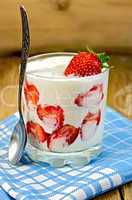 Yogurt thick with strawberries and spoon on board