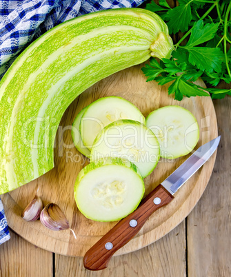 Zucchini green with garlic and knife on board