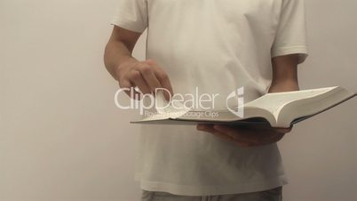 young man holding a bible scrolls. camera movement