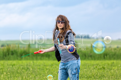 Beautiful Young Woman make Blowing Bubbles