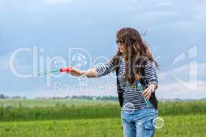 Beautiful Young Woman make Blowing Bubbles