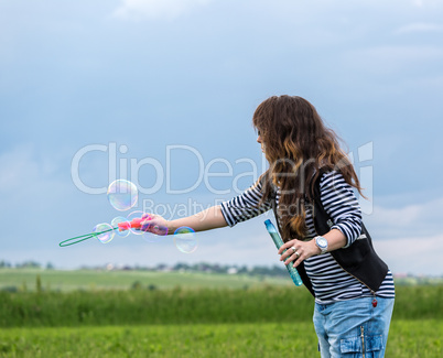 Beautiful Young Woman make Blowing Bubbles