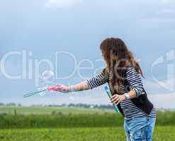 Beautiful Young Woman make Blowing Bubbles