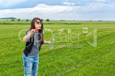 Beautiful Young Woman make Blowing Bubbles