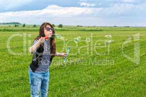 Beautiful Young Woman make Blowing Bubbles