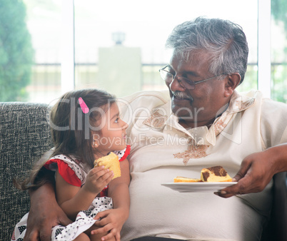 Grandparent and grandchild eating cake