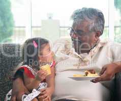 Grandparent and grandchild eating cake