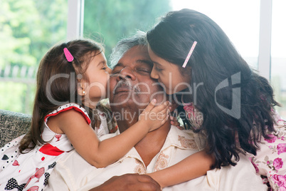 Grandchildren kissing grandparent