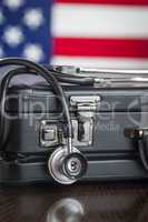 Briefcase and Stethoscope Resting on Table with American Flag Be
