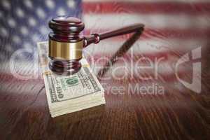 Wooden Gavel Resting on Money with American Flag Reflection