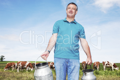 farmer with milk churns at his cows